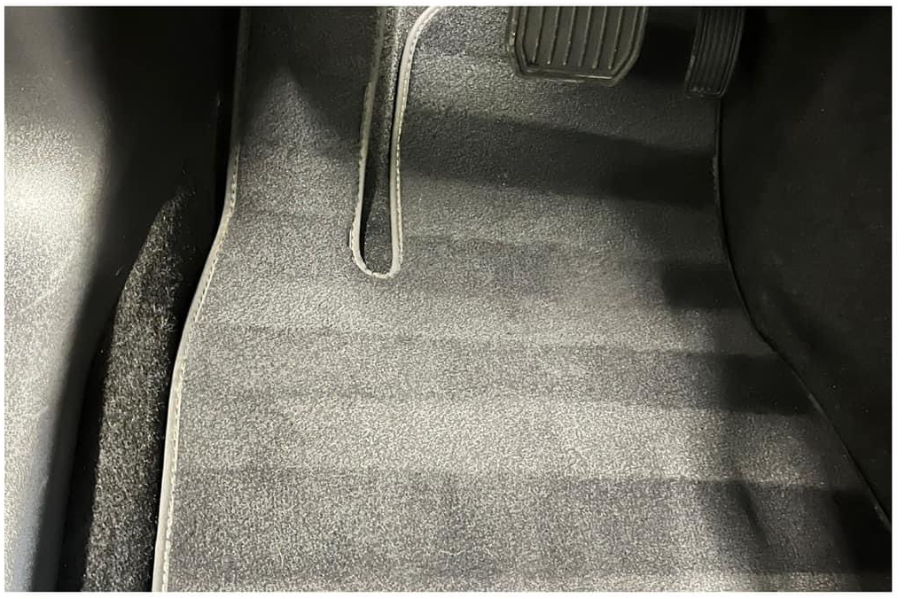 Tesla driver floor after detailing with foreign material removed and surfaces restored